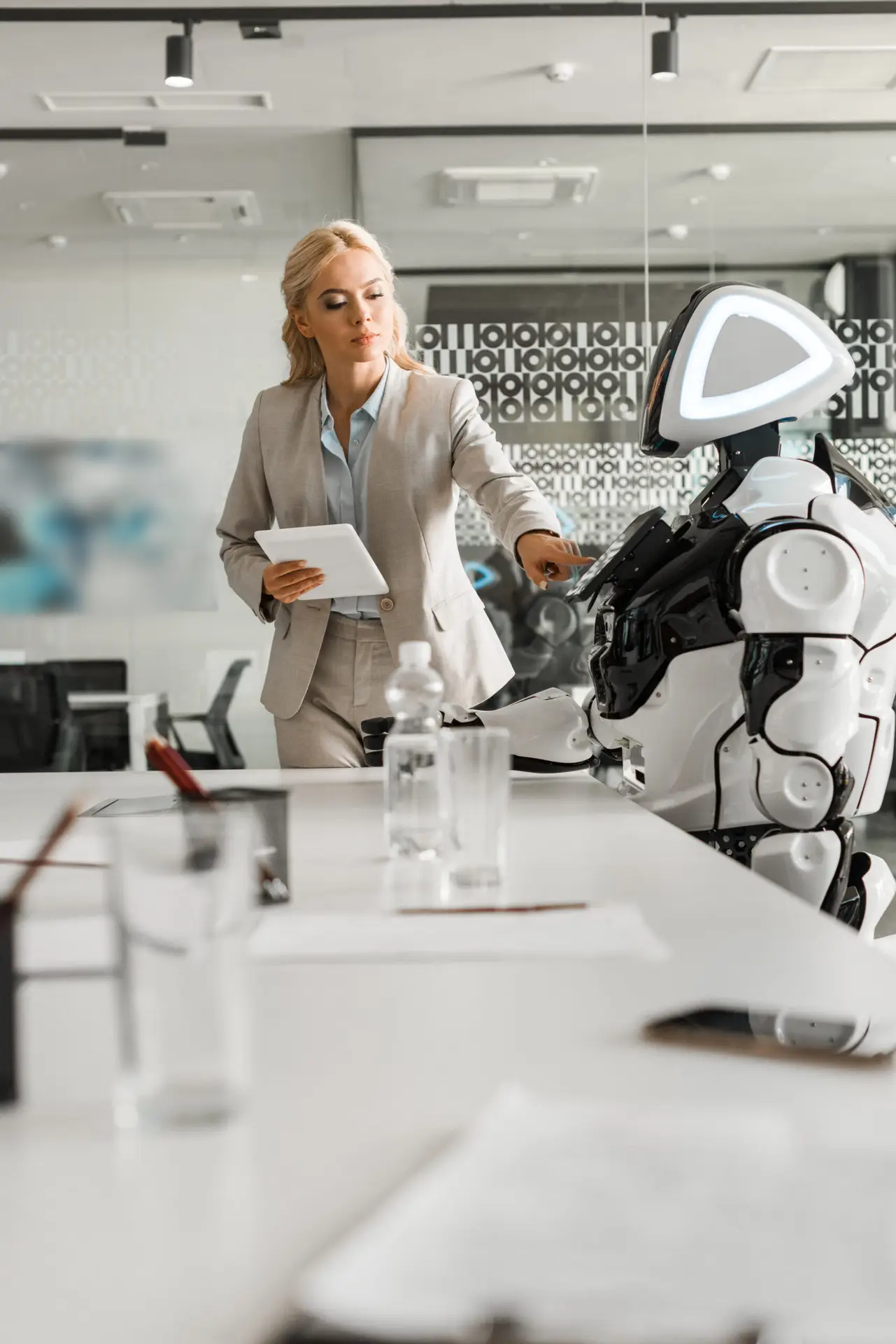 selective focus of attractive businesswoman operating robot while holding digital tablet