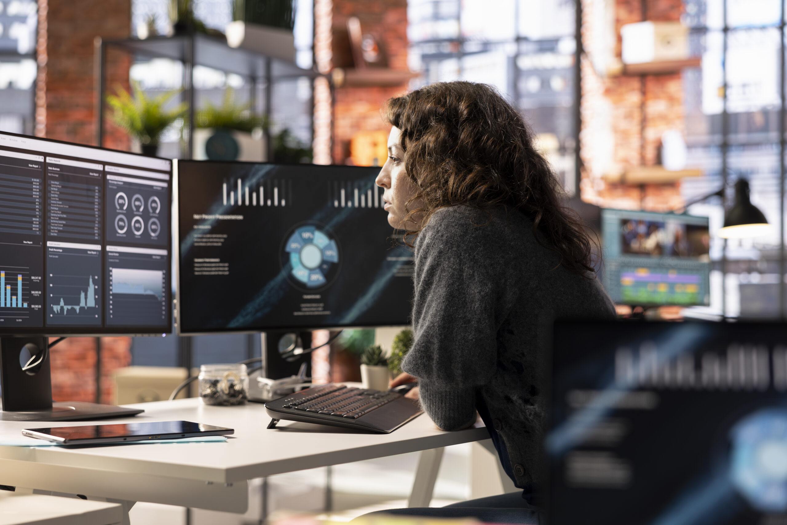 Young woman watching business conference infographics on computer screen, looking over statistics on online portfolio. Analyst in apartment looking at business presentation dashboard.
