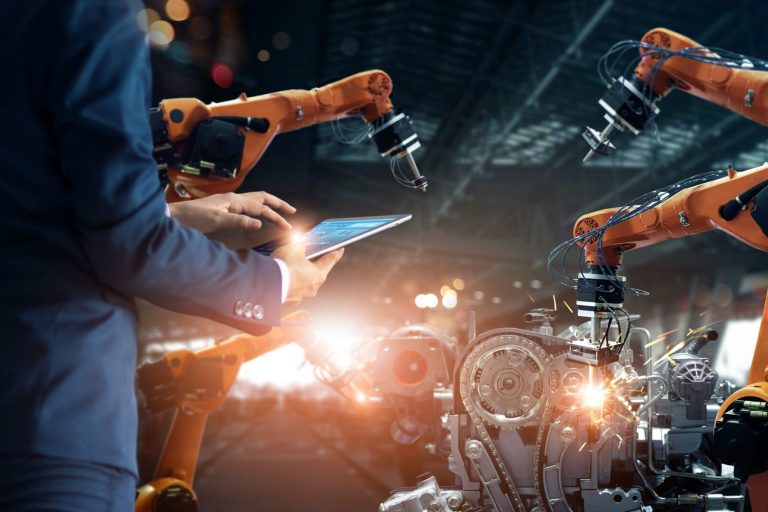 Manager engineer check and control automation robot arms machine in intelligent factory industrial on real time monitoring system software. Welding robotics and digital manufacturing operation.